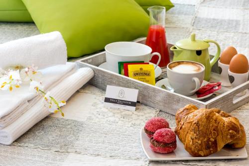 a tray with breakfast foods and a cup of coffee at Hotel Villa Truentum in Martinsicuro