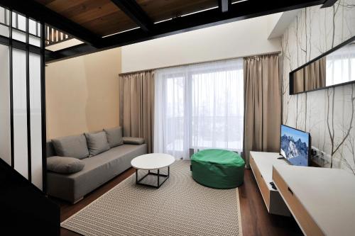 a living room with a couch and a table at APLEND Vila Olívia in Smokovce