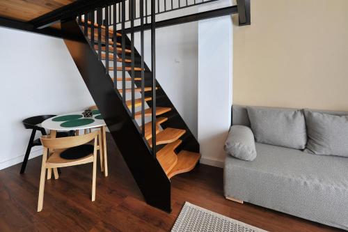 a living room with a staircase and a table and a couch at APLEND Vila Olívia in Smokovce