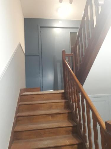 a stairway with a wooden rail and a door at Chalet du Doumet - Appart LUZ centre - parking et garage individuel ferme - draps et serviettes inclus in Luz-Saint-Sauveur