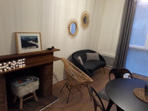 a living room with a chair and a fireplace at Chalet du Doumet - Appart LUZ centre - parking et garage individuel ferme - draps et serviettes inclus in Luz-Saint-Sauveur