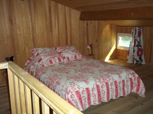 ビュイ・レ・バロニにあるChambre d'hôte Domaine de Bois joliの木製の部屋にベッド1台が備わるベッドルーム1室があります。