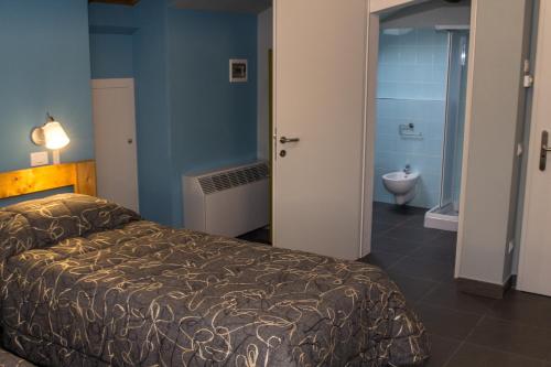a bedroom with a bed and a bathroom with a toilet at B&B Bortolino in Viadana