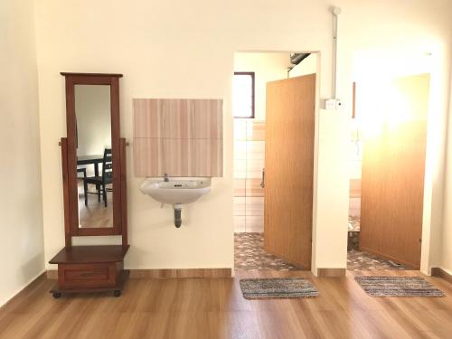 ein Bad mit einem Waschbecken und einem Spiegel in der Unterkunft SingSport Holiday House in Mersing