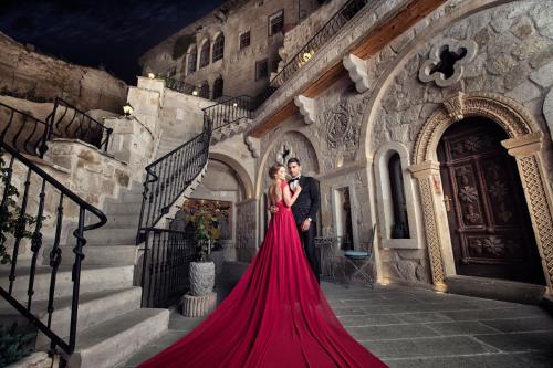 a bride and groom standing on the steps of a building at Elika Cave Suites & Spa in Ortahisar