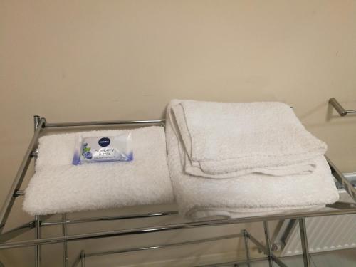 a towel rack with white towels on it at Caftop Aparthotels Wenlock Manchester in Manchester