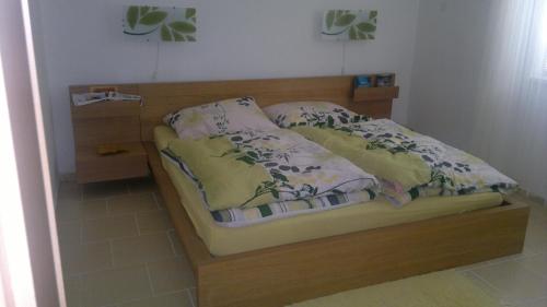 a bed with a wooden head board and pillows on it at Apartmán Srní in Srní