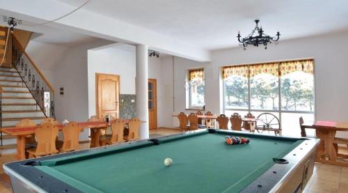 a living room with a pool table and dining room at Winnica Spisz in Łapsze Niżne