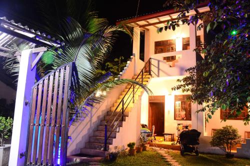 a house with a staircase in front of it at night at Surfing Life in Ahangama