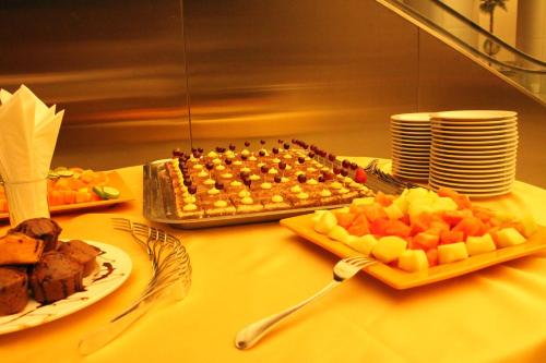 a table with a tray of food and plates of fruit at Swiss Inn Nexus Hotel in Addis Ababa