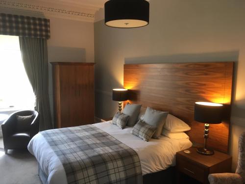 une chambre d'hôtel avec un lit et une chaise dans l'établissement Ardshiel Hotel, à Campbeltown