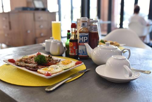 a plate of food on a table with eggs and tea at Regal Inn Umhlanga Gateway in Durban