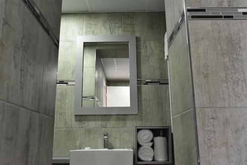 a bathroom with a sink and a mirror at Regal Inn Umhlanga Gateway in Durban