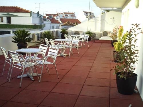 a patio with tables and chairs on a balcony at Hotel Serafim in Almodôvar