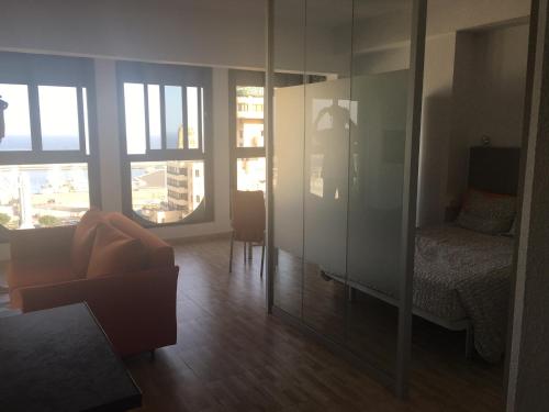 サンタクルス・デ・テネリフェにあるVacacional panorámica al mar centro Santa Cruzのソファ、ベッド、鏡が備わる客室です。