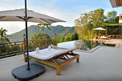 a patio with a table and an umbrella next to a pool at Perfect View Pool Villa in Koh Tao