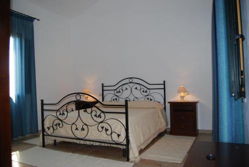 a bedroom with a bed with a black frame at Agriturismo Villa Gaia in Càbras