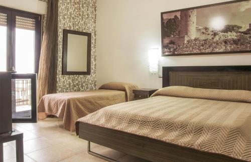 a hotel room with two beds and a painting on the wall at Hotel Grazia Eboli in Eboli