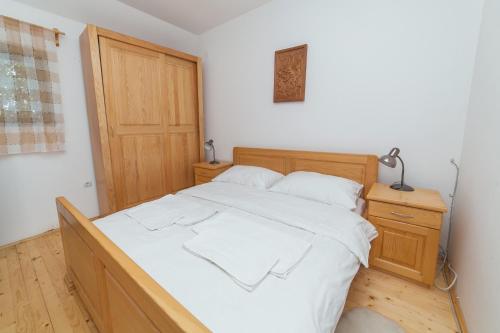 a bedroom with a large bed with white sheets at Hotel & Resort Gacka in Mojkovac