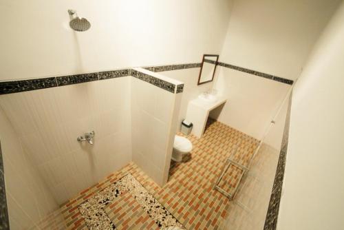 a bathroom with a shower and a toilet in it at Warung Ary & Home Stay in Amed