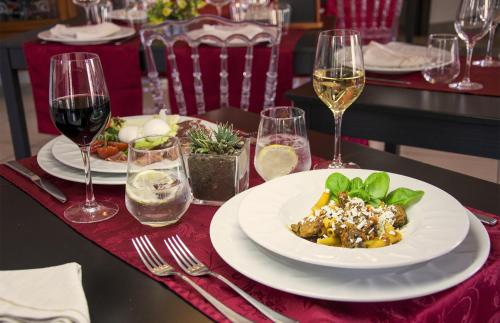 a table with a plate of food and glasses of wine at Hotel Grazia Eboli in Eboli