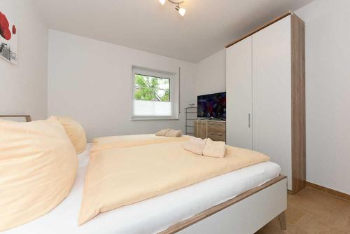 ベンサージールにあるFerienwohnung Seeperleの白いベッドルーム(大型ベッド1台、窓付)