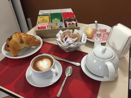 een tafel met een kopje koffie en een theepot bij Hotel Bogart 2 in Milaan