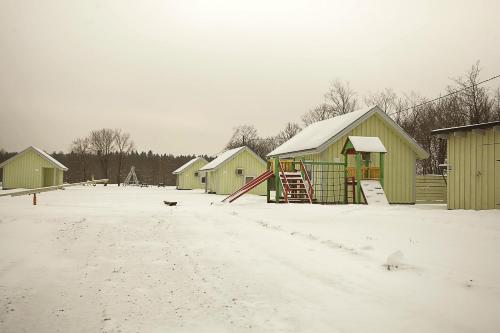 a snow covered playground with houses and a slide at Valaste Puhkeküla in Kohtla-Järve