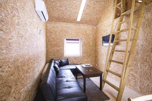 a living room with a couch and a ladder at Valaste Puhkeküla in Kohtla-Järve