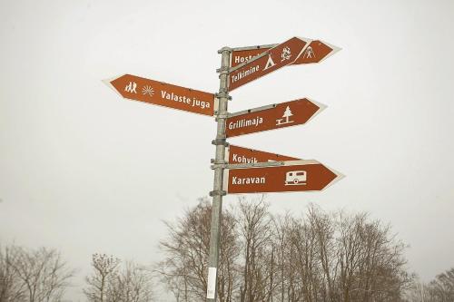 a street sign with street signs on a pole at Valaste Puhkeküla in Kohtla-Järve