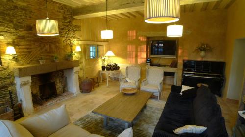 un salon avec un canapé et une cheminée dans l'établissement Les Demeures de Marie, à Pacé