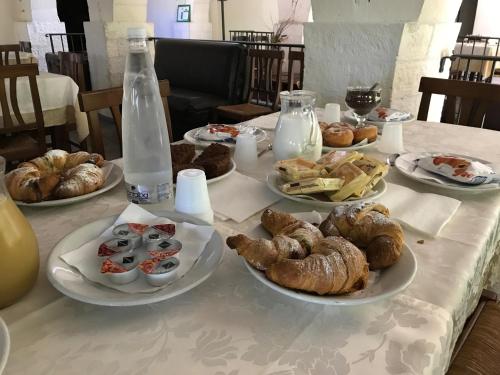 a table with plates of pastries and a bottle of water at B&B Agriturismo 'A Cunziria in Vizzini