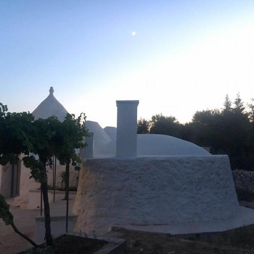 a white building with a chimney on top of it at Trullo Grazioso Luxury in Ceglie Messapica