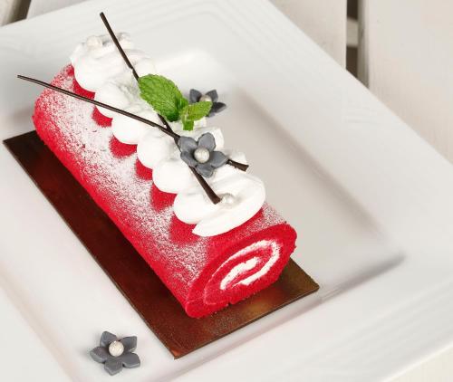 a red cake on a plate on a table at Novotel Goa Dona Sylvia Resort in Cavelossim