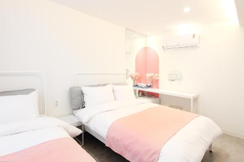a bedroom with two beds and a desk with a mirror at Orbit - For foreigners only in Seoul