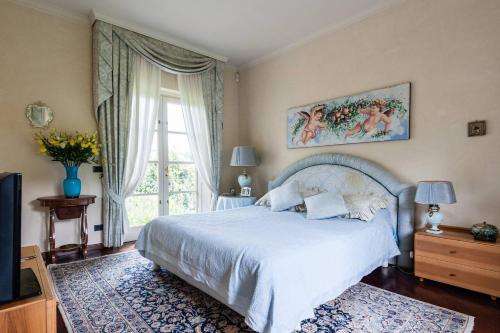 Un dormitorio con una cama blanca y una ventana. en Villa Bianca, en Lucca