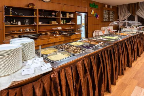 a buffet line with many different types of food at Hotel Barátság in Hajdúszoboszló
