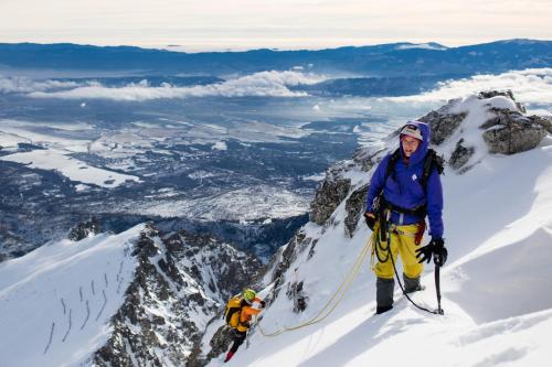 a man standing on top of a snow covered mountain at Apartmán Tatranská Lomnica in Tatranská Lomnica