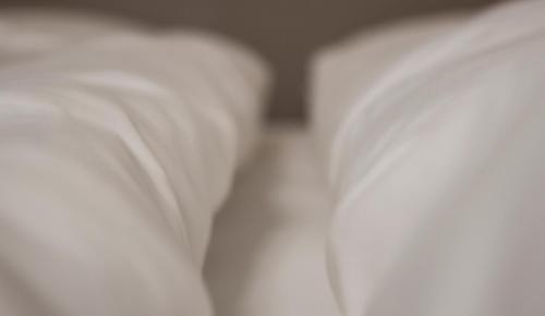 a close up of two beds with white sheets at Lava Apartments & Rooms in Akureyri