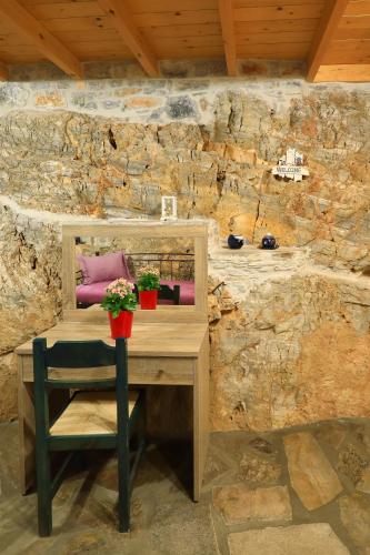 a wooden desk with a purple pillow and plants on it at Armonia by Grispos Villas in Schinoussa