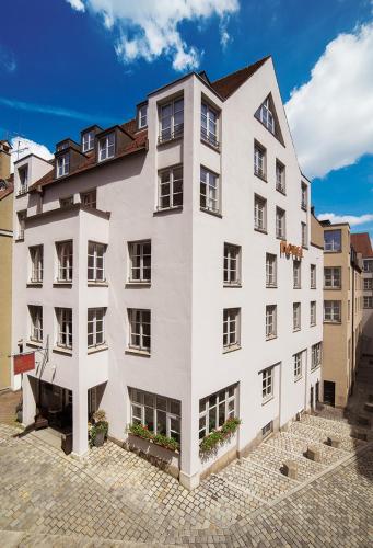 a large white building with windows on a street at Hotel am Rathaus in Augsburg