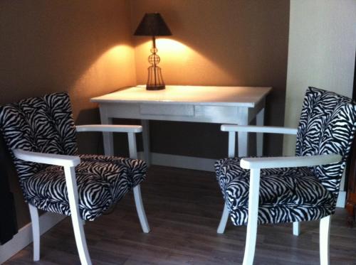 two chairs and a desk in a room with a table at Chambres d'Hôtes du Clos Semper Felix in Sainte-Bazeille