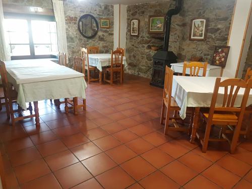 a dining room with tables and chairs and a fireplace at Casa da Ponte in Ferreira