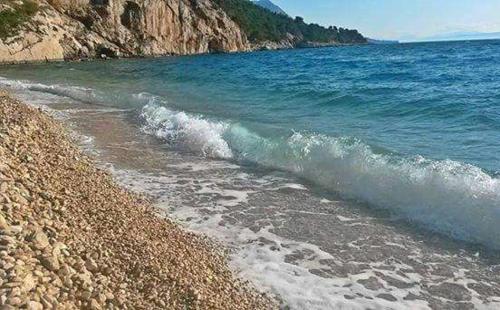 a beach with a rocky shore and the ocean at Apartman Teta Jadre in Makarska