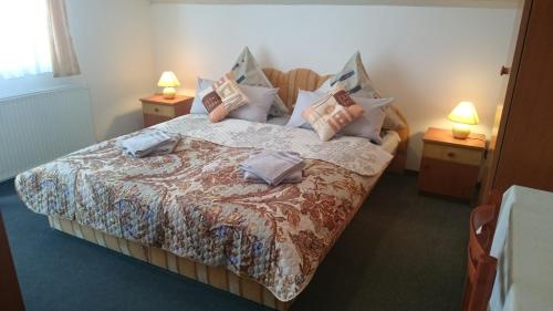 una camera da letto con un grande letto con cuscini sopra di Natalie Appartment a Bük