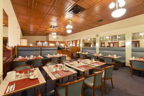a restaurant with wooden ceilings and tables and chairs at Austria Classic Hotel Wien in Vienna