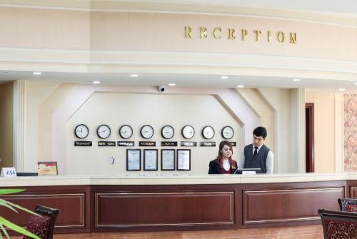 a man and a woman standing at a reception desk at Hotel Uzbekistan in Tashkent