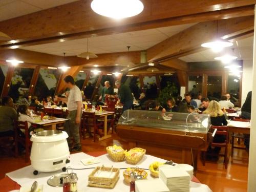 grupa ludzi siedzących przy stolikach w restauracji w obiekcie Le Chalet du Ticou w mieście Bolquere Pyrenees 2000