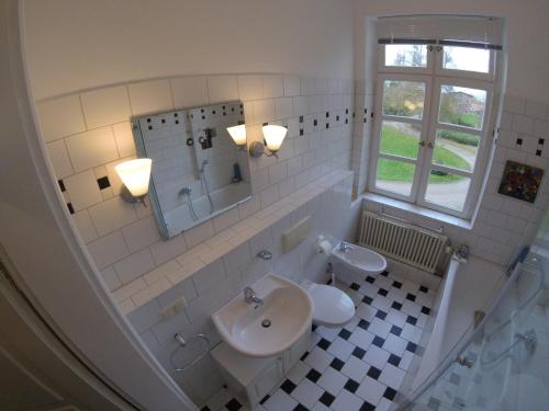 a white bathroom with a sink and a mirror at Schloss Lelkendorf - Fewo Prebberede in Lelkendorf