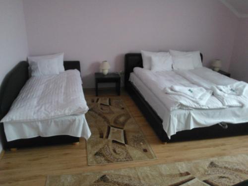 two beds sitting next to each other in a room at Pazonyi Fogadó és Étterem in Nyírpazony
